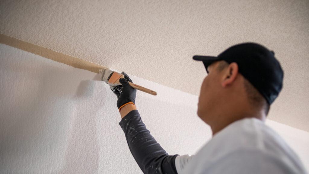 A painter from That 1 Painter North Jersey painting the trim of a wall.