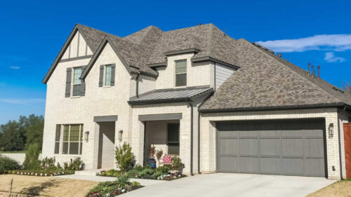 Large white brick house with dark accents painted by professional painters in Tuttle