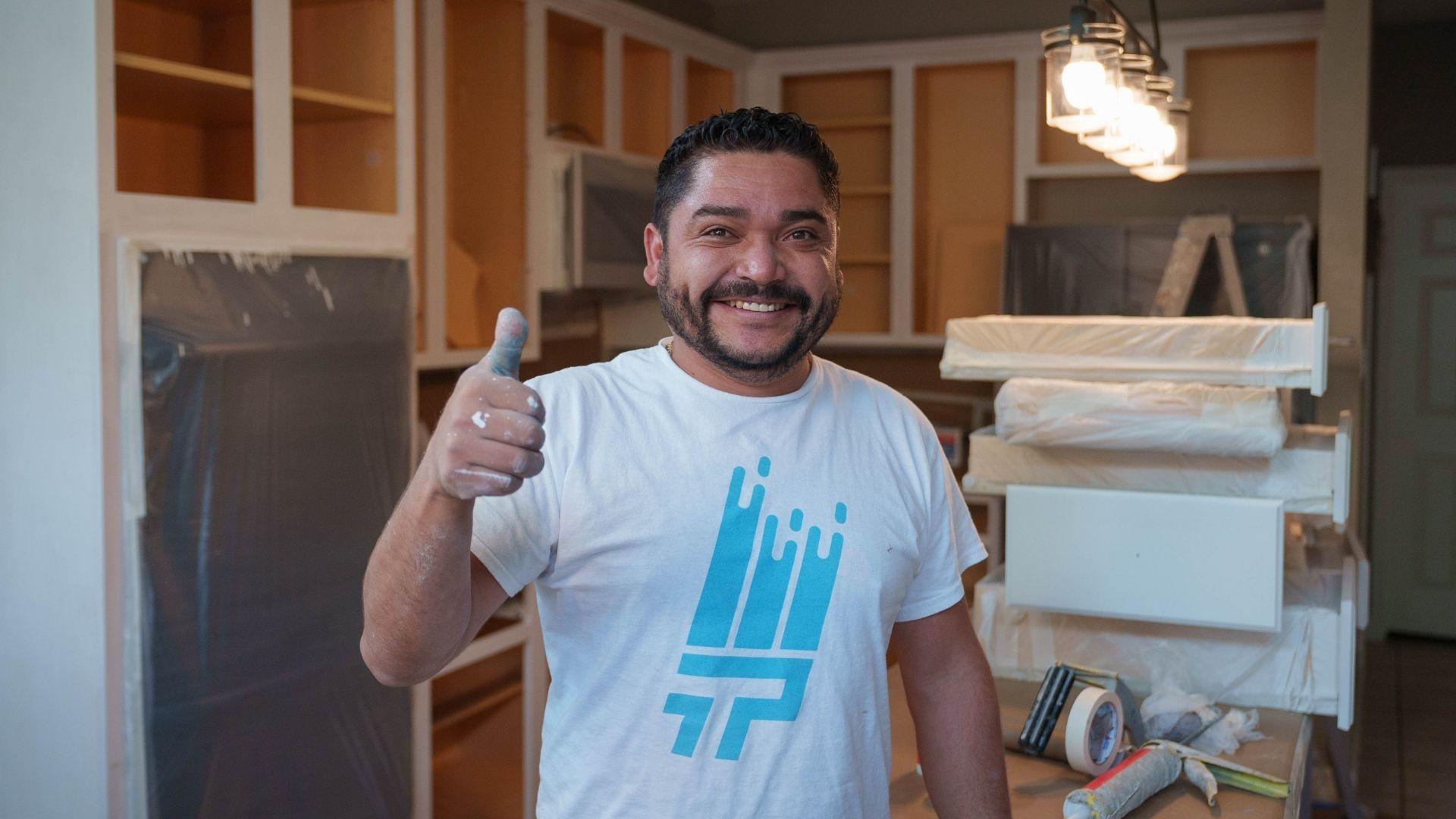 That 1 Painter Pearland professional painter smiling and holding up a thumbs up while working on a cabinet painting project.