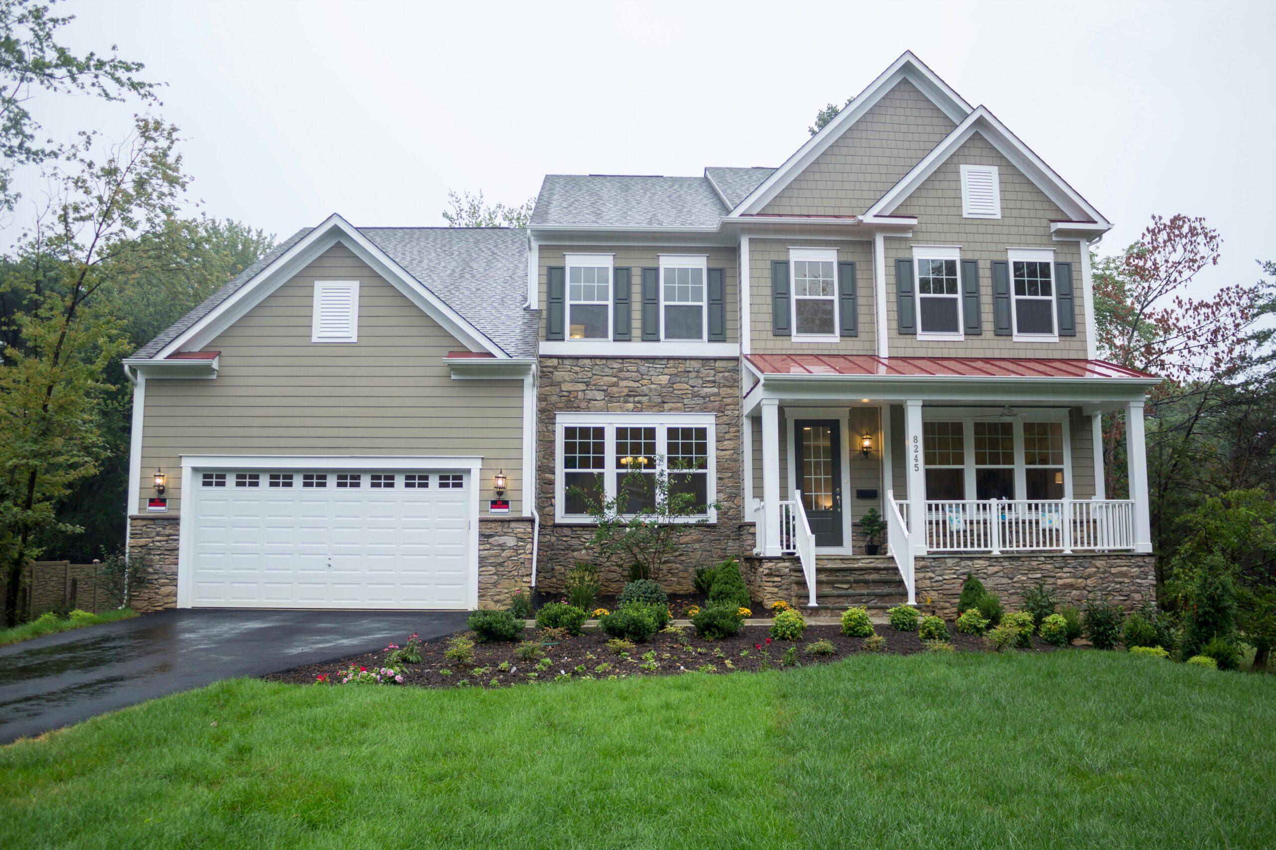 Beautiful tan house with white trim painted by professional painters in Cabin John, MD