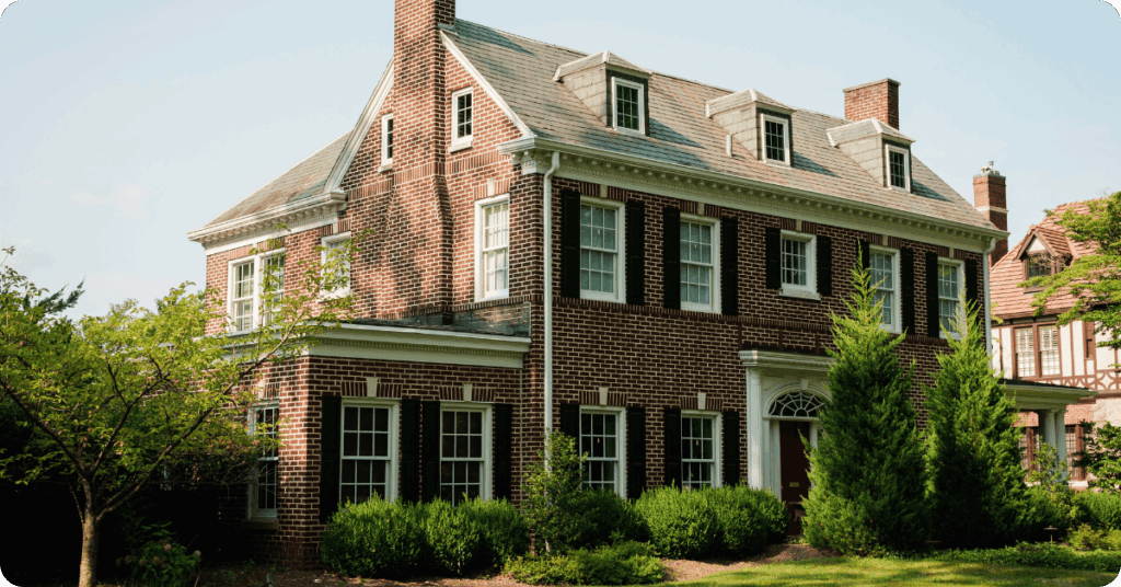 exterior painting of red brick home with white trim and black shutter windows for that 1 painter