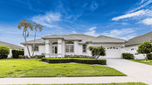 Exterior of a large luxury home with palm trees painted by professional painters in Snell Isle, Florida.