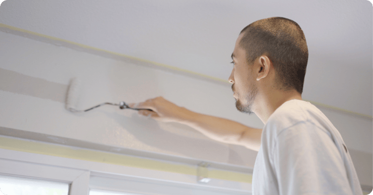 hiring experts professional painter using a roller paint with white painter for That 1 painter Salt Lake City
