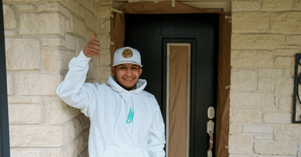 Professional painter in San Antonio holding up the shaka sign while standing in front of a recently painted black door_That 1 Painter