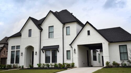 Large white house with dark accents painted by professional painters in Austin