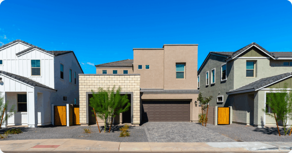 Exterior painting in Scottsdale, AZ of a modern stucco home with cube-style architecture, mixed exterior textures, dark trim, and xeriscaped front yard by that 1 painter.
