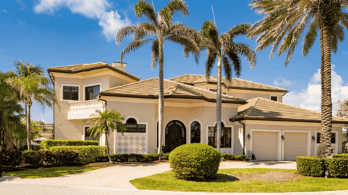 Exterior yellow tan home with palm trees painted by Professional painters in Westchase, Tampa Bay