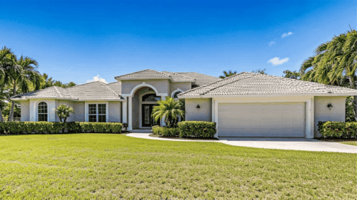 Exterior yellow light gray home with palm trees painted by Professional painters in Hyde Park, Tampa Bay