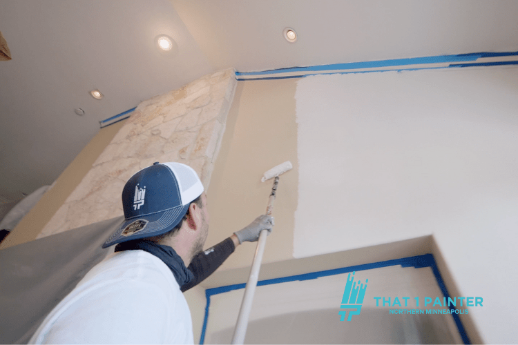 A professional painter from That 1 Painter Northern Minneapolis skillfully painting a tall, elegant interior wall.