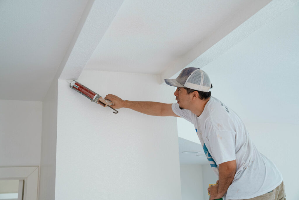 High-quality caulking application on white wall trim by professional painter in St. Paul, MN