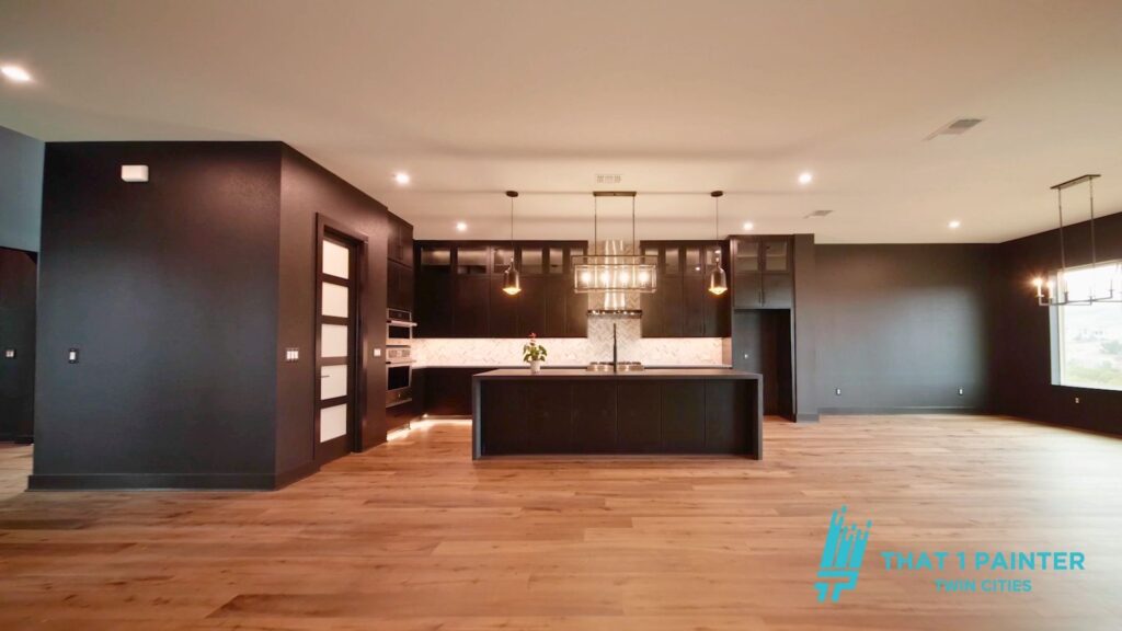 Modern open-concept interior with wood floors and dark accent walls painted by the best painters in the Twin Cities.