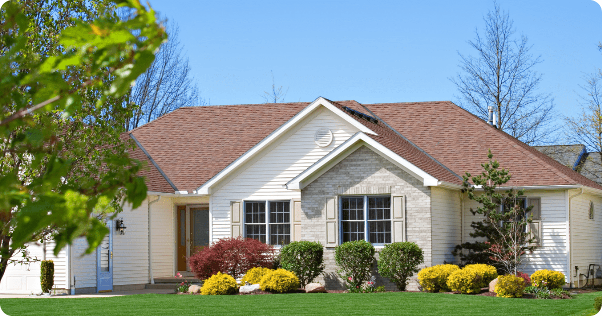 Exterior painting in Wadsworth, OH of a two-story contemporary craftsman-style home featuring taupe board-and-batten siding, shake accents, and a dark entry door framed by manicured landscaping by that 1 painter.