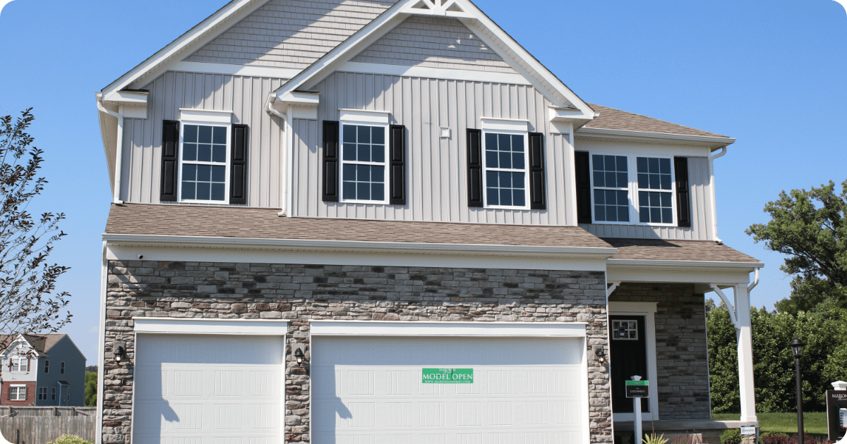 Exterior painting in Wadsworth, OH of a craftsman-style home showcasing blue shake siding, white decorative trim, a small gable balcony, and detailed eaves under a charcoal gray shingle roof by that 1 painter.