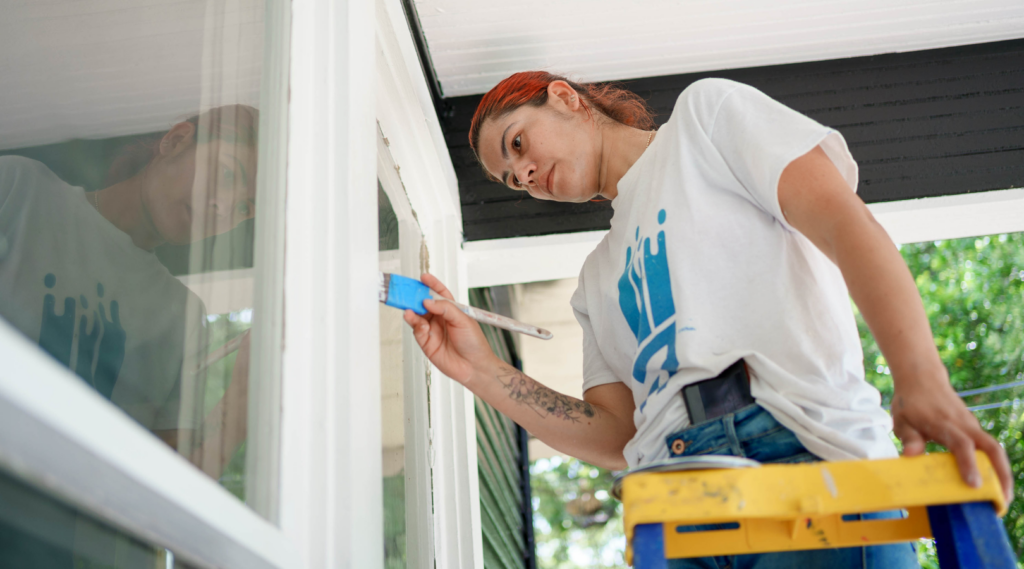 That 1 painter using a paint brush to paint window trim.