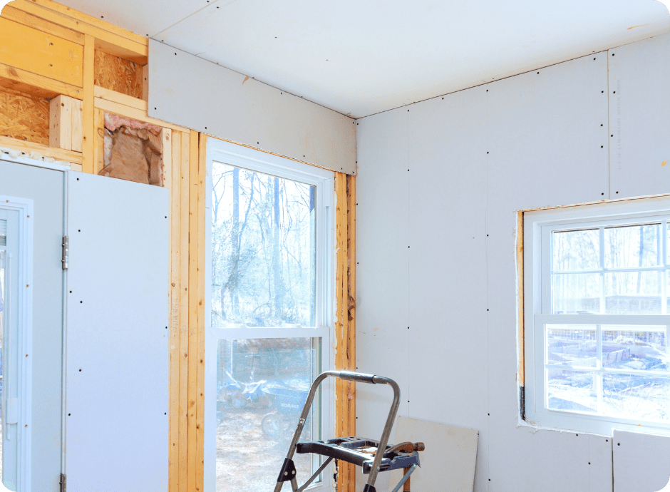 drywall repair being done on the inside of a home with step stool in the room for that 1 painter