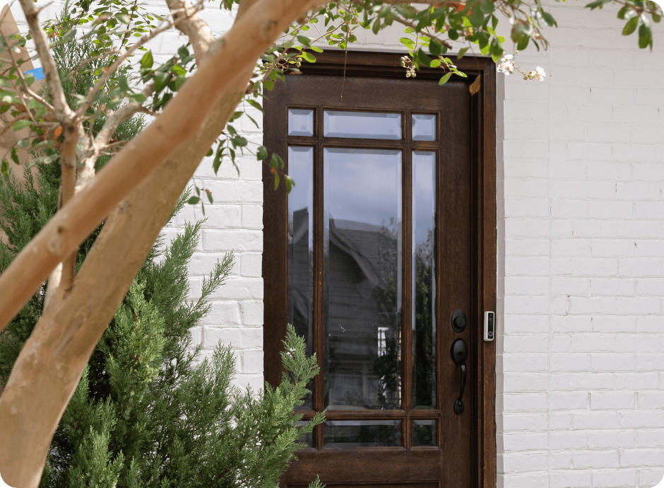 white brick painting with tree in front of house with bushes with that 1 painter